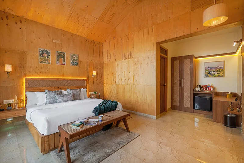 Wood-panelled bedroom with wardrobe and en-suite dresser at Manovan Resort